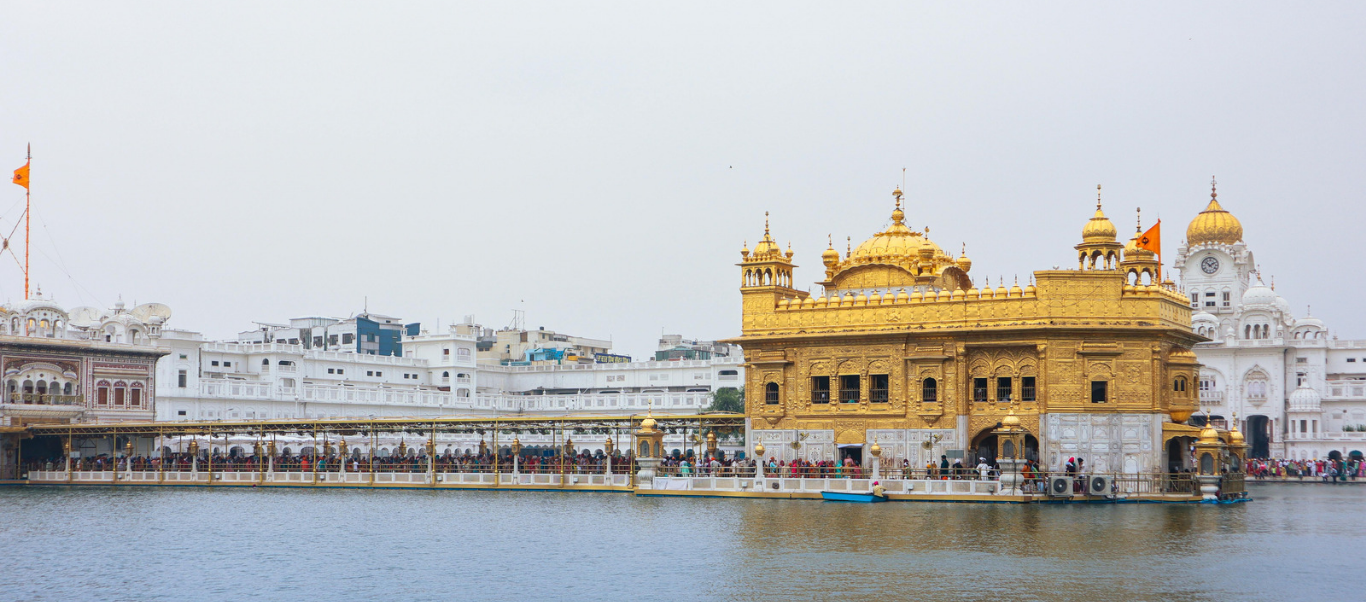 The stunning Golden Temple in Amritsar illuminated at night, a spiritual stop on the Himachal tour.