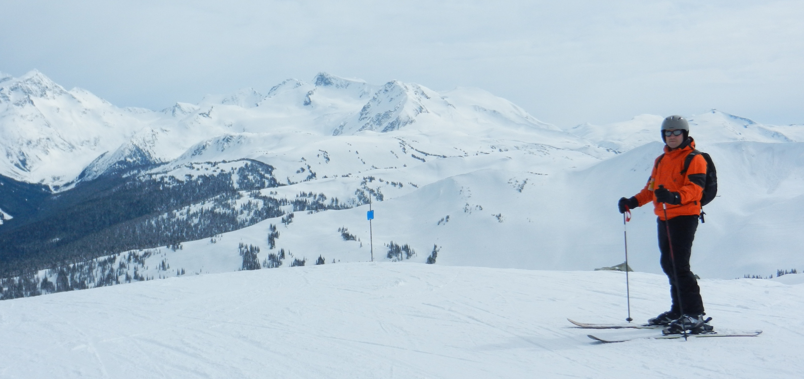 Manali winter tourism: A person in orange gear skiing on the snow-covered Himalayan slopes in Himachal Pradesh